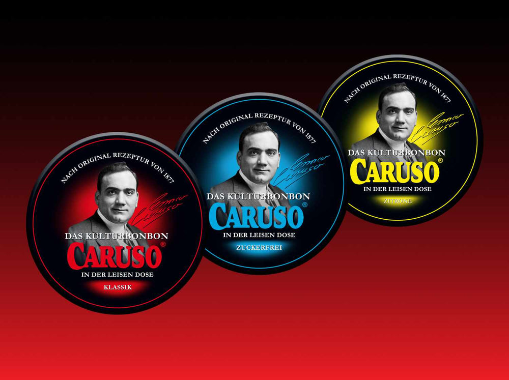 Die drei Sorten des CARUSO Kulturbonbons in der leisen Dose: Klassik (rot), Zuckerfrei (blau) und Zitrone (gelb), nebeneinander vor rotem Hintergrund.